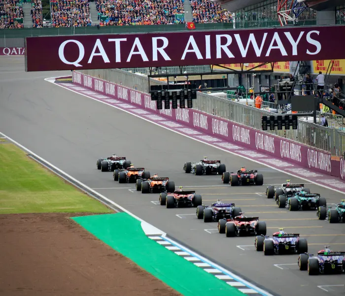 Formula One race cars lined up on a racetrack