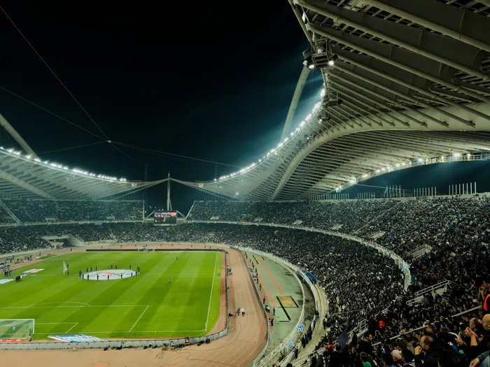 Crowded stadium under bright lights at night during a match