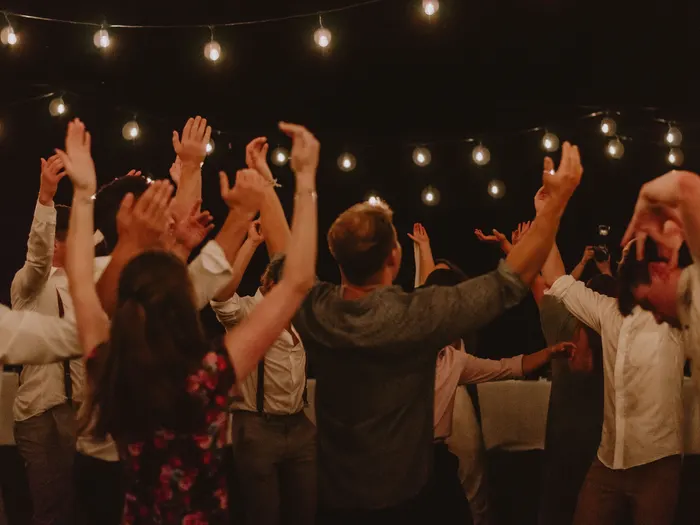 Guests celebrating under string lights at an evening gala, the kind of special event we provide limousine service for